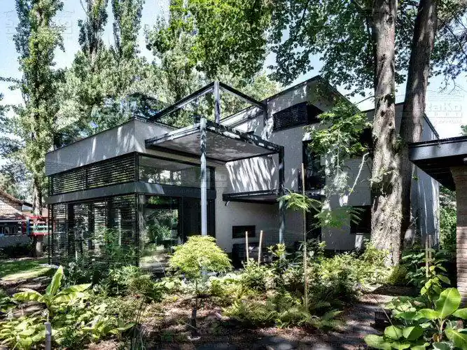 Letisztult két szintes lakóépület, nagy üvegfelületekkel